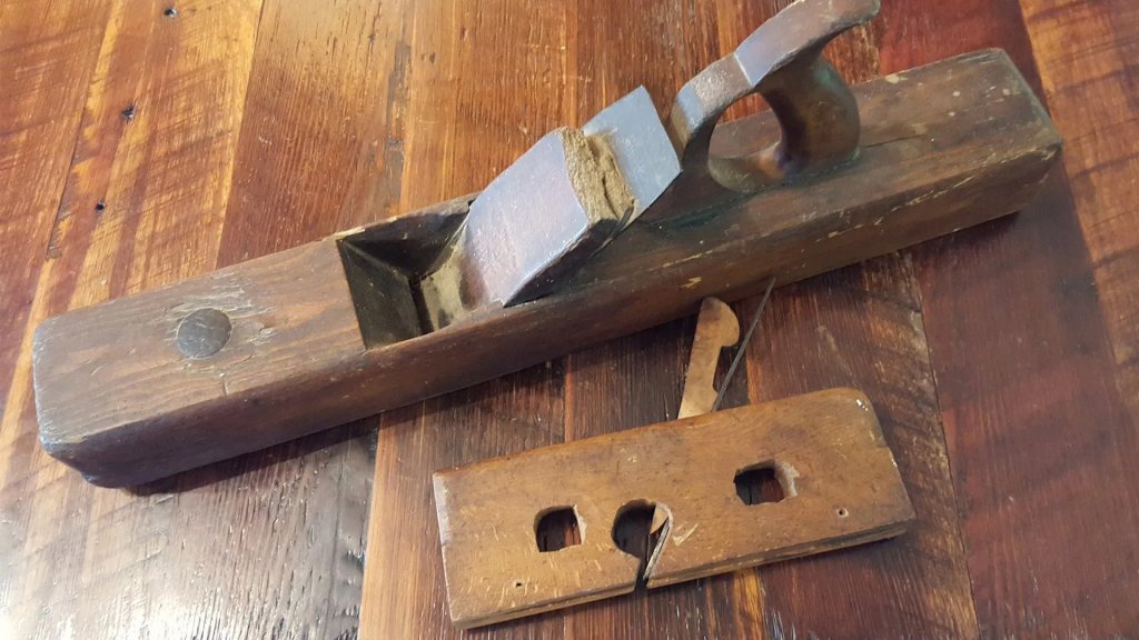 vintage hand planer on a background of antique heart pine milled flooring.